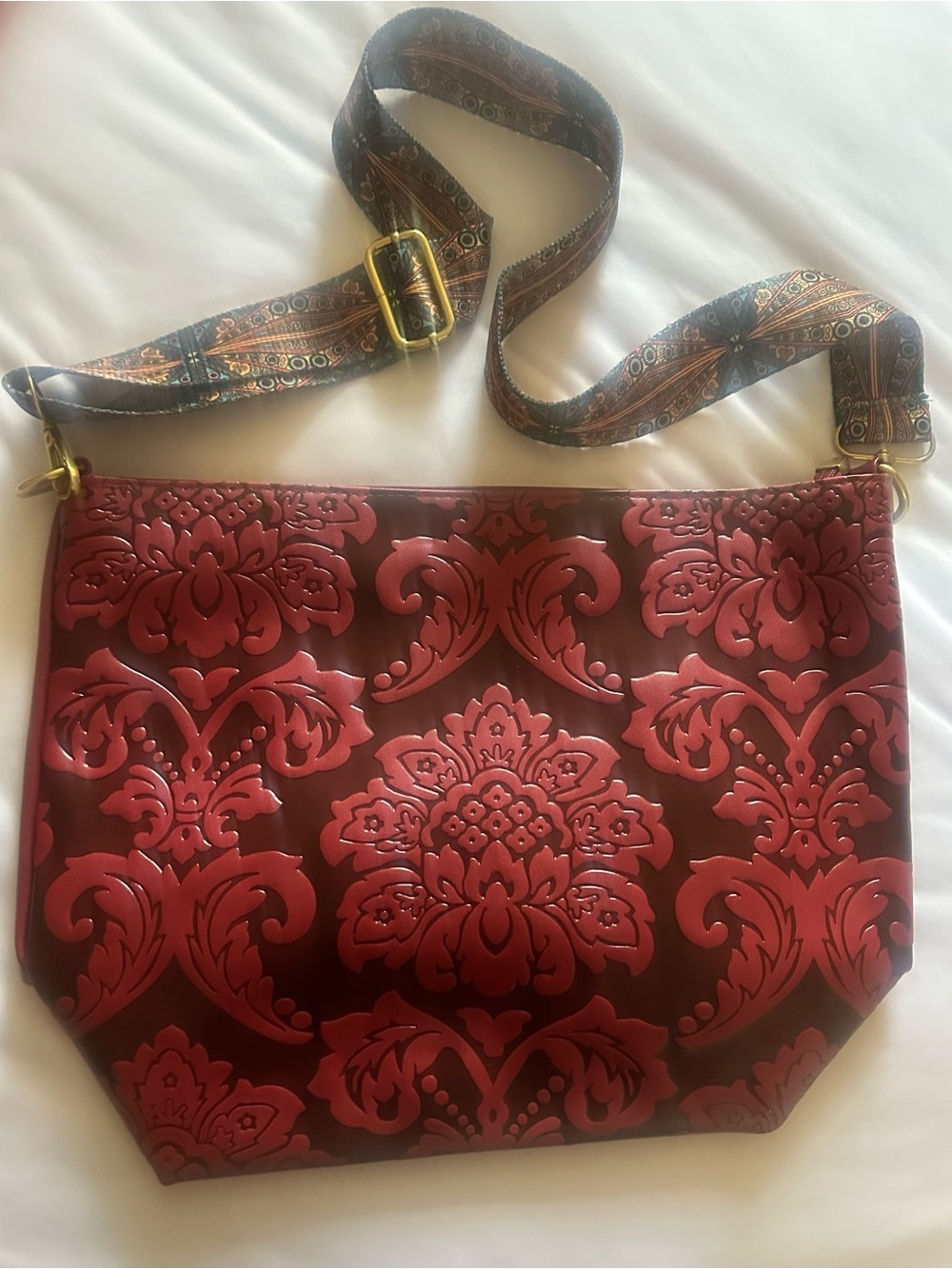 Floral-Embossed Red Shoulder Bag with Patterned Strap